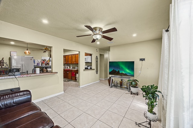 tiled living room with ceiling fan and a textured ceiling