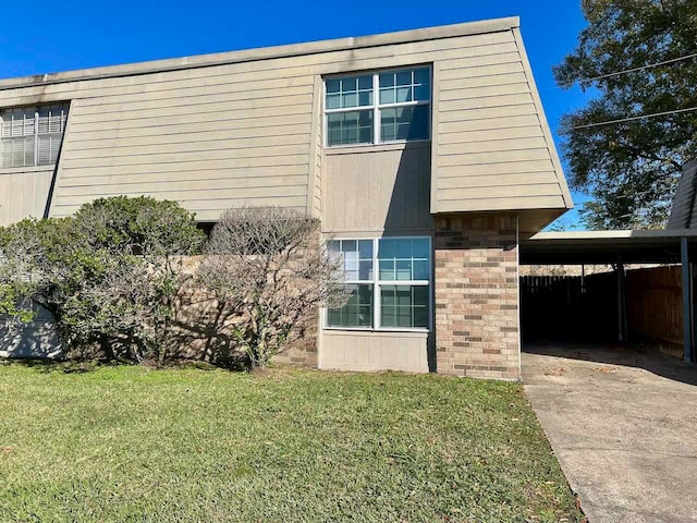 view of front of home with a carport and a front lawn