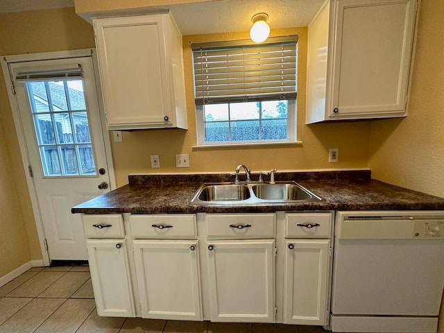 kitchen featuring white dishwasher, white cabinetry, light tile flooring, and sink