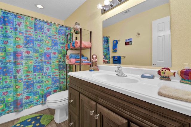 full bathroom with visible vents, vanity, wood finished floors, toilet, and a shower with curtain