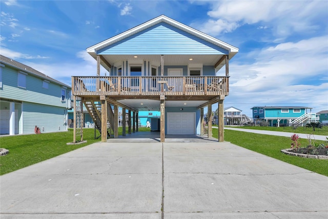 beach home featuring a wooden deck, a front yard, and a garage