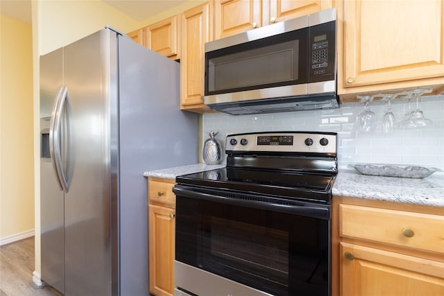 kitchen with decorative backsplash, appliances with stainless steel finishes, wood finished floors, and light brown cabinets