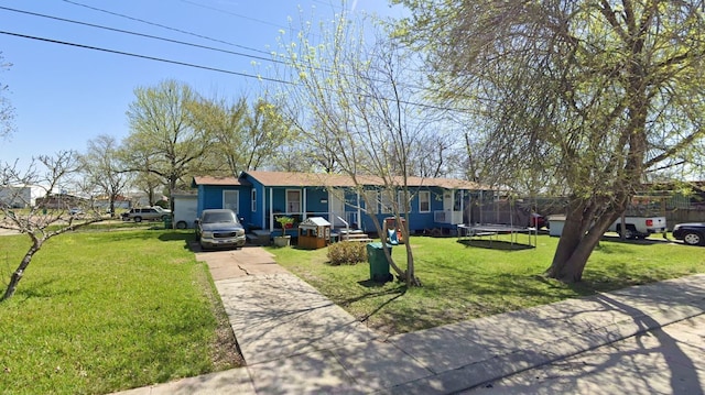 ranch-style house with a front yard and a trampoline