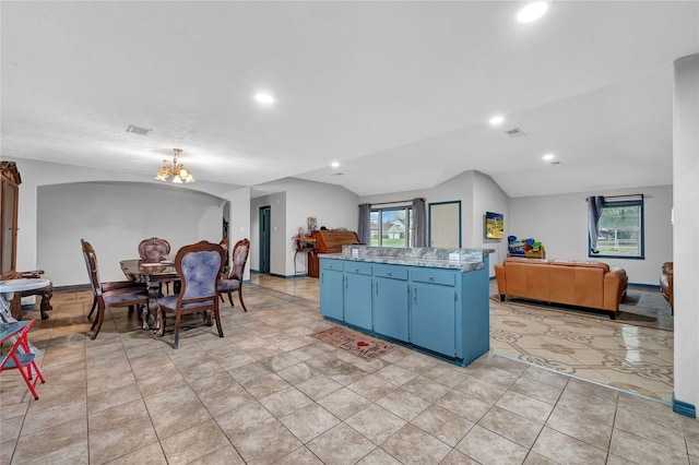 kitchen featuring a notable chandelier, blue cabinets, and a wealth of natural light