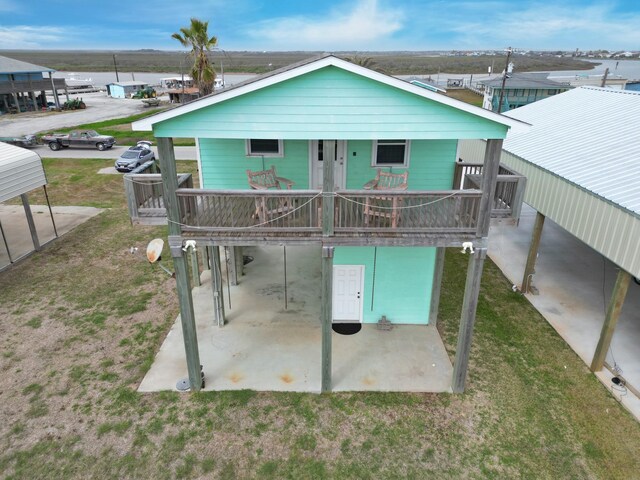 back of house featuring a patio area and a lawn