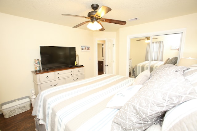 bedroom with dark hardwood / wood-style flooring, ceiling fan, and a closet