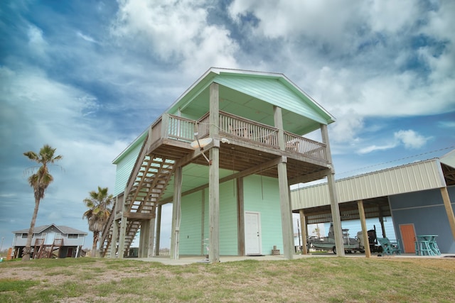 rear view of house with a balcony and a lawn