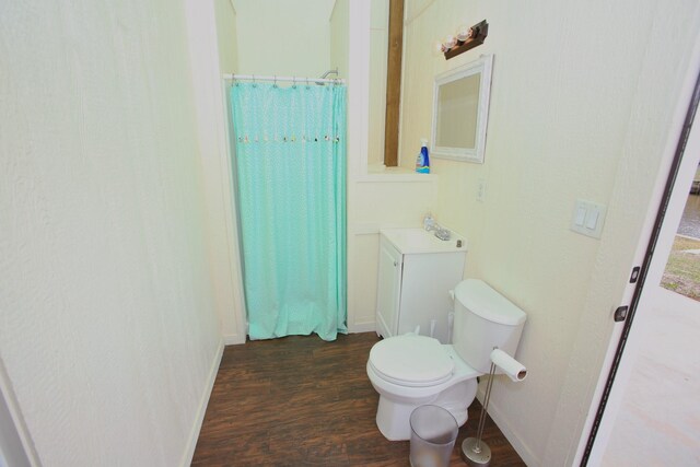 bathroom with hardwood / wood-style flooring, toilet, and vanity