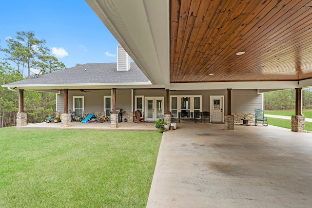 rear view of property with a patio area, ceiling fan, french doors, and a yard