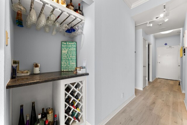 interior space with crown molding, light hardwood / wood-style floors, and track lighting