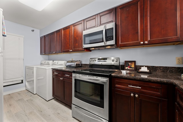 kitchen with light hardwood / wood-style floors, separate washer and dryer, appliances with stainless steel finishes, and dark stone counters