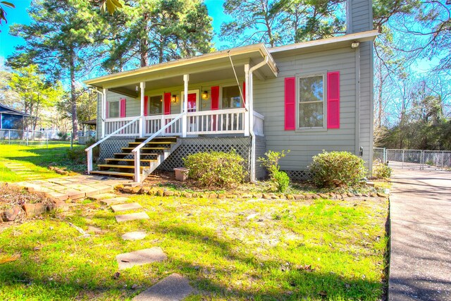 view of front facade featuring covered porch and a front yard