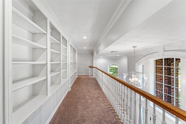 corridor featuring carpet floors, an inviting chandelier, and crown molding