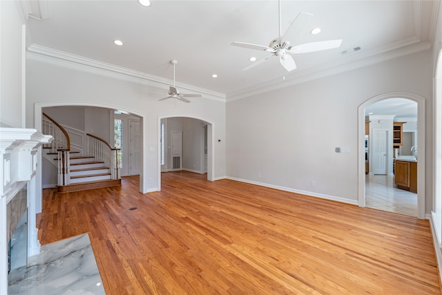 unfurnished living room featuring crown molding, ceiling fan, a high end fireplace, and light hardwood / wood-style floors