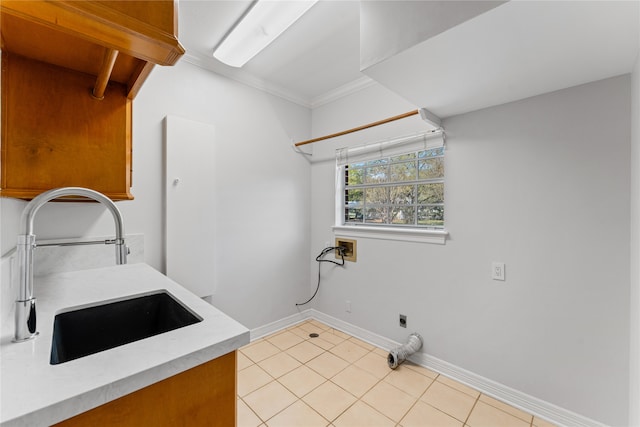 washroom with crown molding, hookup for a washing machine, sink, and light tile patterned floors