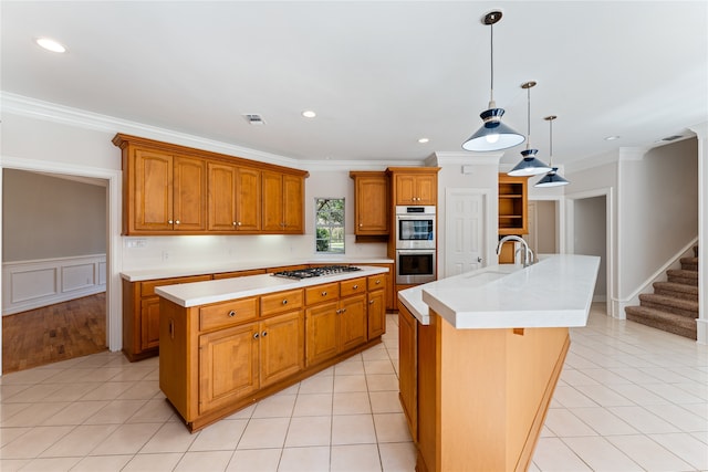 kitchen featuring ornamental molding, sink, a kitchen island with sink, decorative light fixtures, and appliances with stainless steel finishes