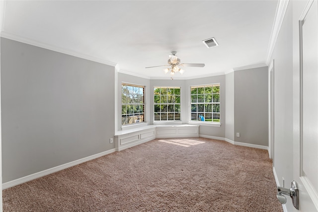 spare room featuring carpet floors, crown molding, and ceiling fan