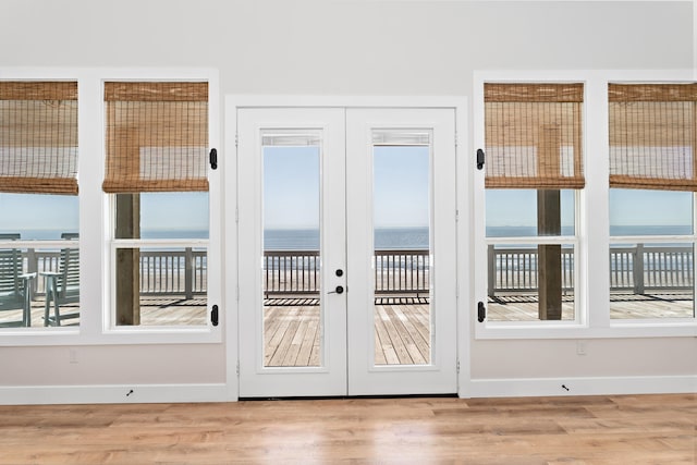 doorway featuring french doors, light hardwood / wood-style floors, and a water view