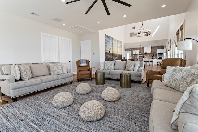 living room featuring a wealth of natural light, dark hardwood / wood-style floors, and ceiling fan with notable chandelier