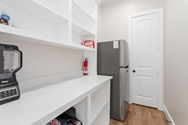 clothes washing area with light hardwood / wood-style floors