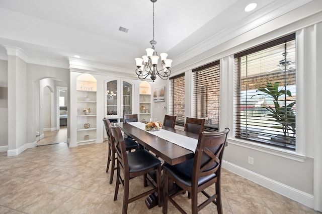 tiled dining area featuring ornamental molding, a chandelier, and built in shelves