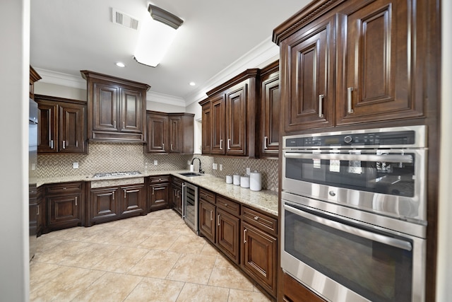 kitchen with backsplash, appliances with stainless steel finishes, light stone countertops, crown molding, and dark brown cabinetry