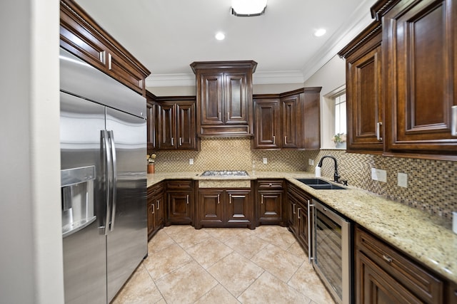 kitchen featuring decorative backsplash, dark brown cabinets, sink, beverage cooler, and appliances with stainless steel finishes