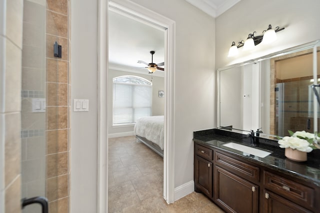 bathroom with a shower with door, tile patterned flooring, crown molding, vanity, and ceiling fan