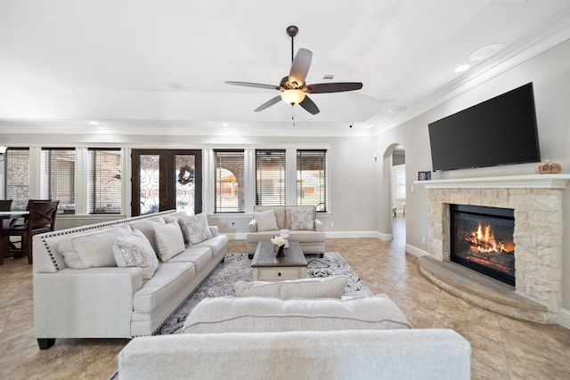 tiled living room with crown molding, a fireplace, and ceiling fan