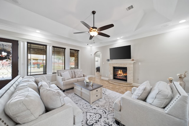 living room with crown molding, a raised ceiling, and ceiling fan