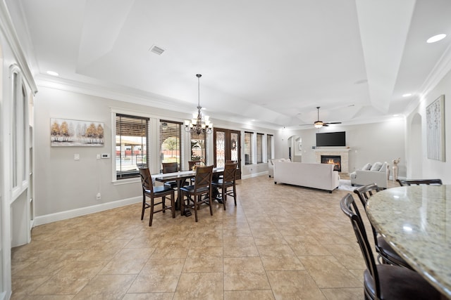 dining area featuring ornamental molding, a tray ceiling, and ceiling fan with notable chandelier