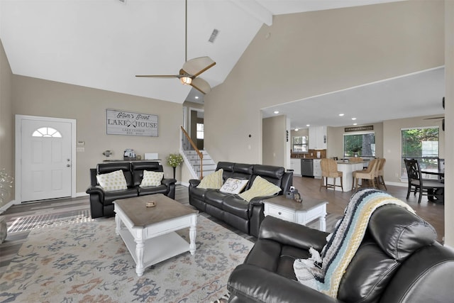 living room featuring high vaulted ceiling, ceiling fan, light hardwood / wood-style flooring, and beamed ceiling