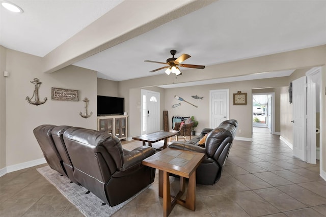 living room featuring ceiling fan, light tile patterned floors, and beamed ceiling