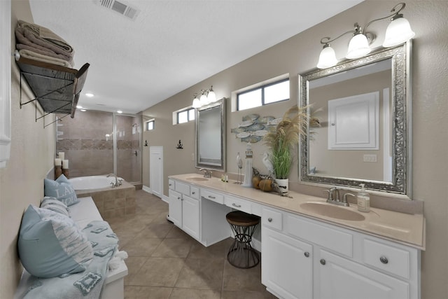 bathroom with tile patterned flooring, plus walk in shower, a textured ceiling, and vanity