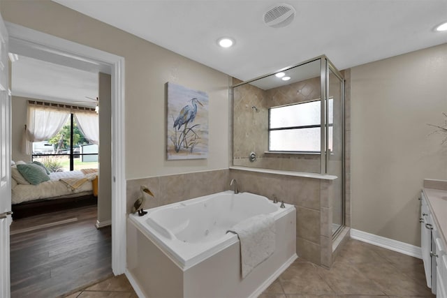 bathroom with independent shower and bath, tile patterned floors, and vanity