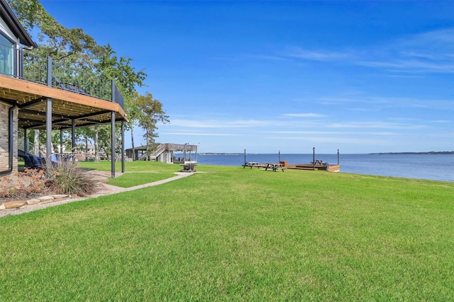 view of yard with a deck with water view