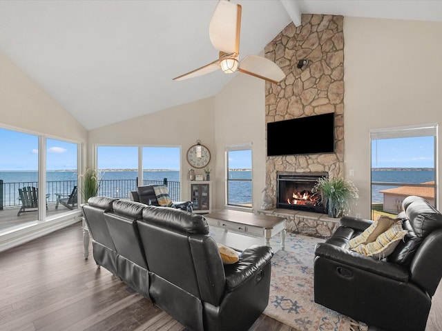 living room with a fireplace, a water view, ceiling fan, high vaulted ceiling, and dark wood-type flooring