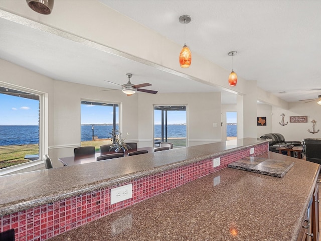 kitchen featuring ceiling fan, pendant lighting, a water view, and plenty of natural light