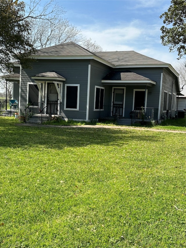 rear view of property featuring a lawn, central air condition unit, and a porch