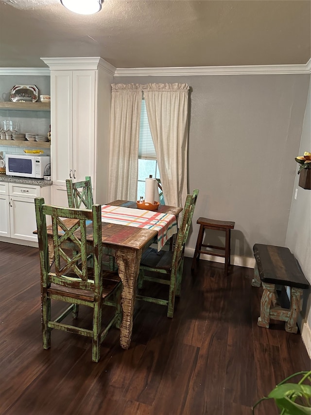 dining area with dark wood-type flooring, a textured ceiling, and crown molding