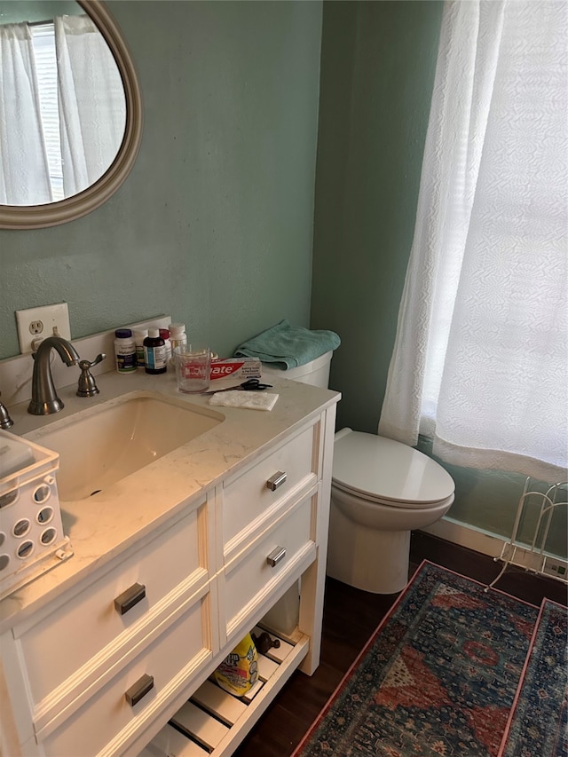 bathroom featuring toilet, hardwood / wood-style floors, and vanity