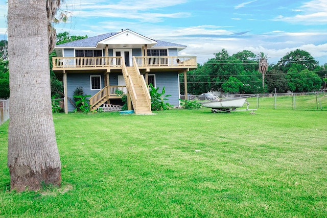 back of house with a wooden deck and a lawn