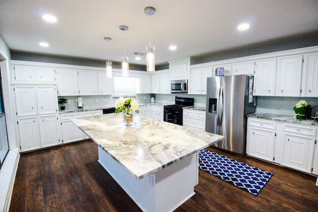 kitchen with white cabinets, a kitchen island, and stainless steel appliances