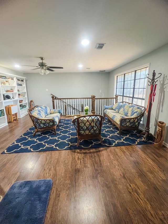 living room with ceiling fan and dark wood-type flooring