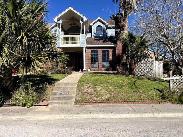 view of front of home featuring a balcony and a front lawn