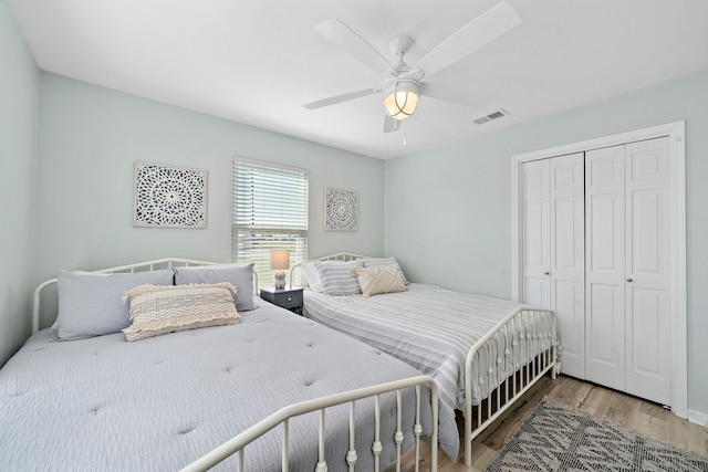 bedroom with a closet, ceiling fan, and light wood-type flooring