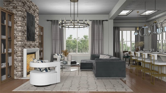 living area featuring a skylight, a chandelier, hardwood / wood-style flooring, and a stone fireplace