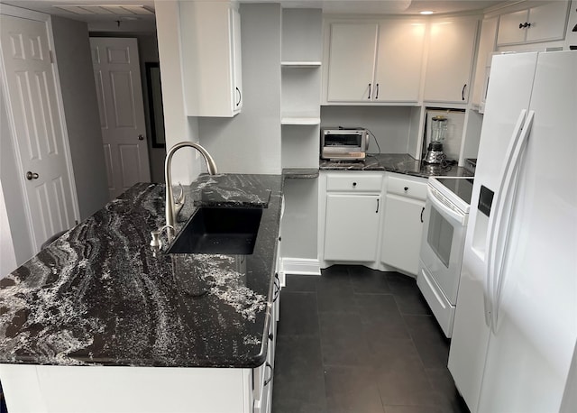 kitchen with sink, white appliances, dark stone countertops, and white cabinets