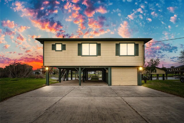 view of front facade with a yard, a garage, and a carport