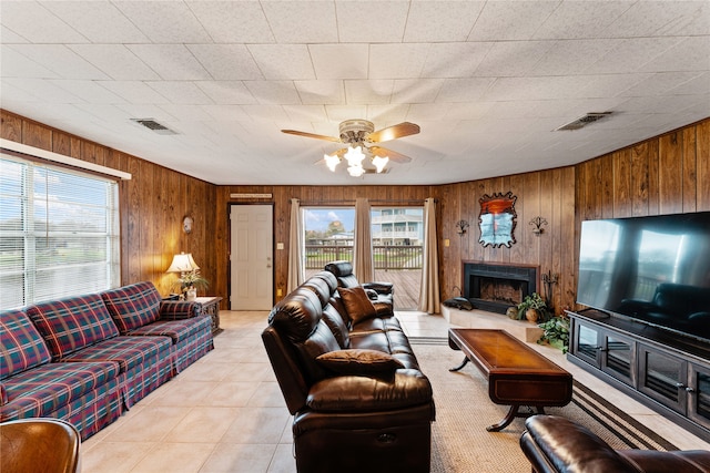 living room featuring ceiling fan and wooden walls